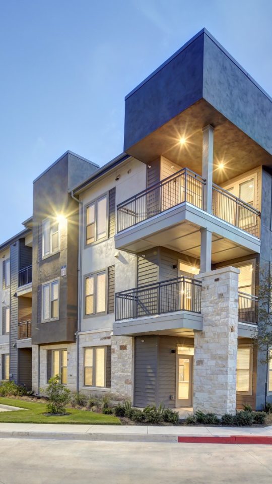 the exterior of an apartment complex at dusk at The  Conley