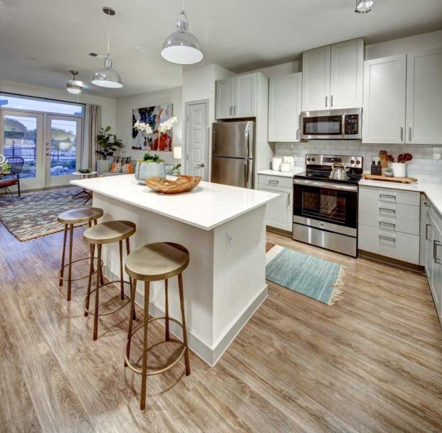 a kitchen with stainless steel appliances and wood floors at The  Conley