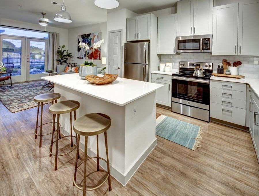 a kitchen with stainless steel appliances and wood floors at The  Conley